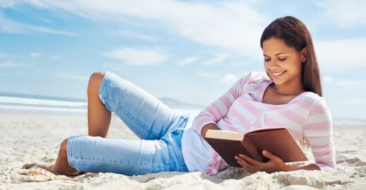 cover image for beta readers showing a woman reading on a beach
