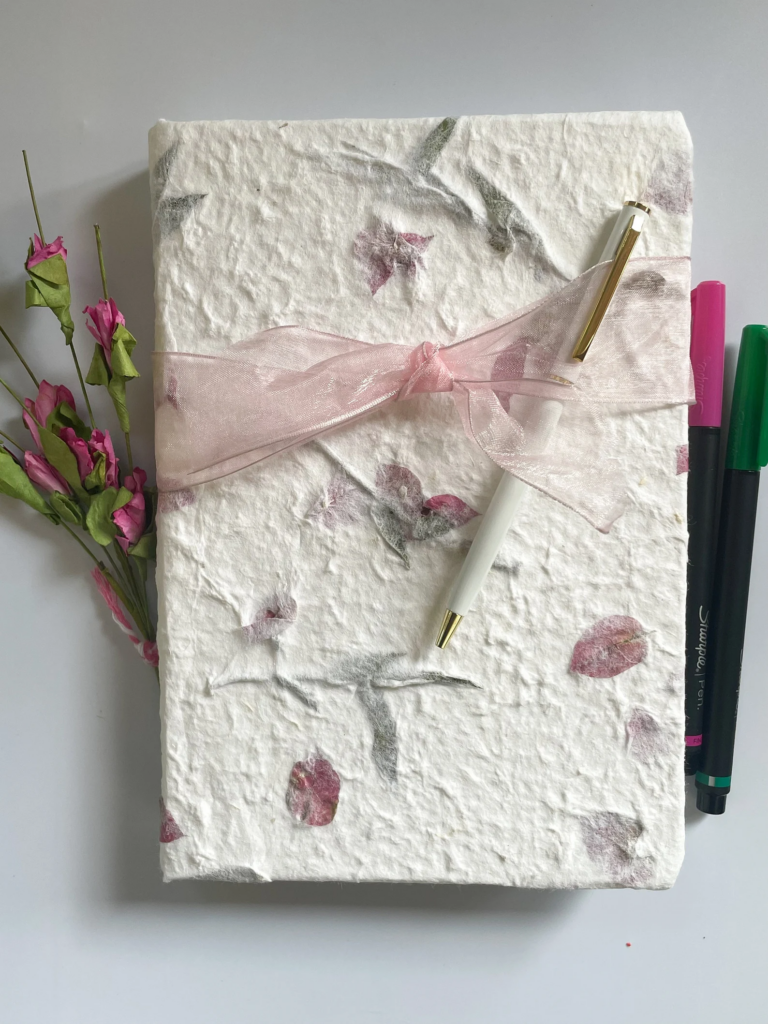 pressed flower journal design with ribbon and white pen